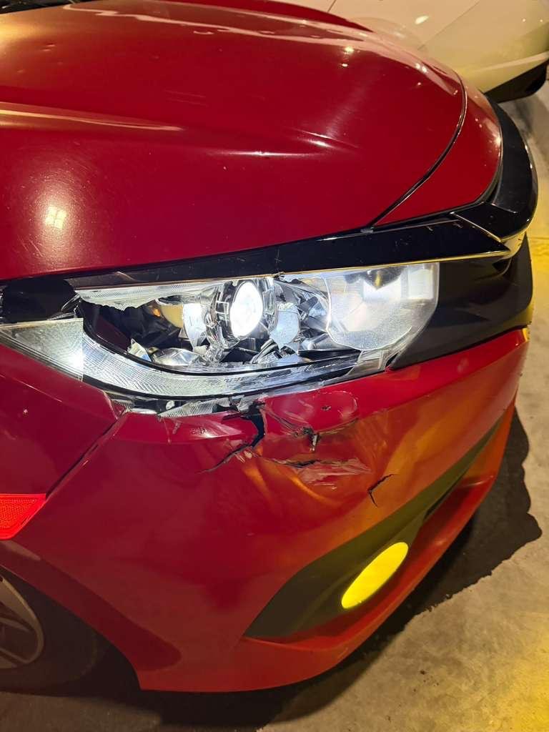 Carro rojo antes de la reparación, con daño en el frente